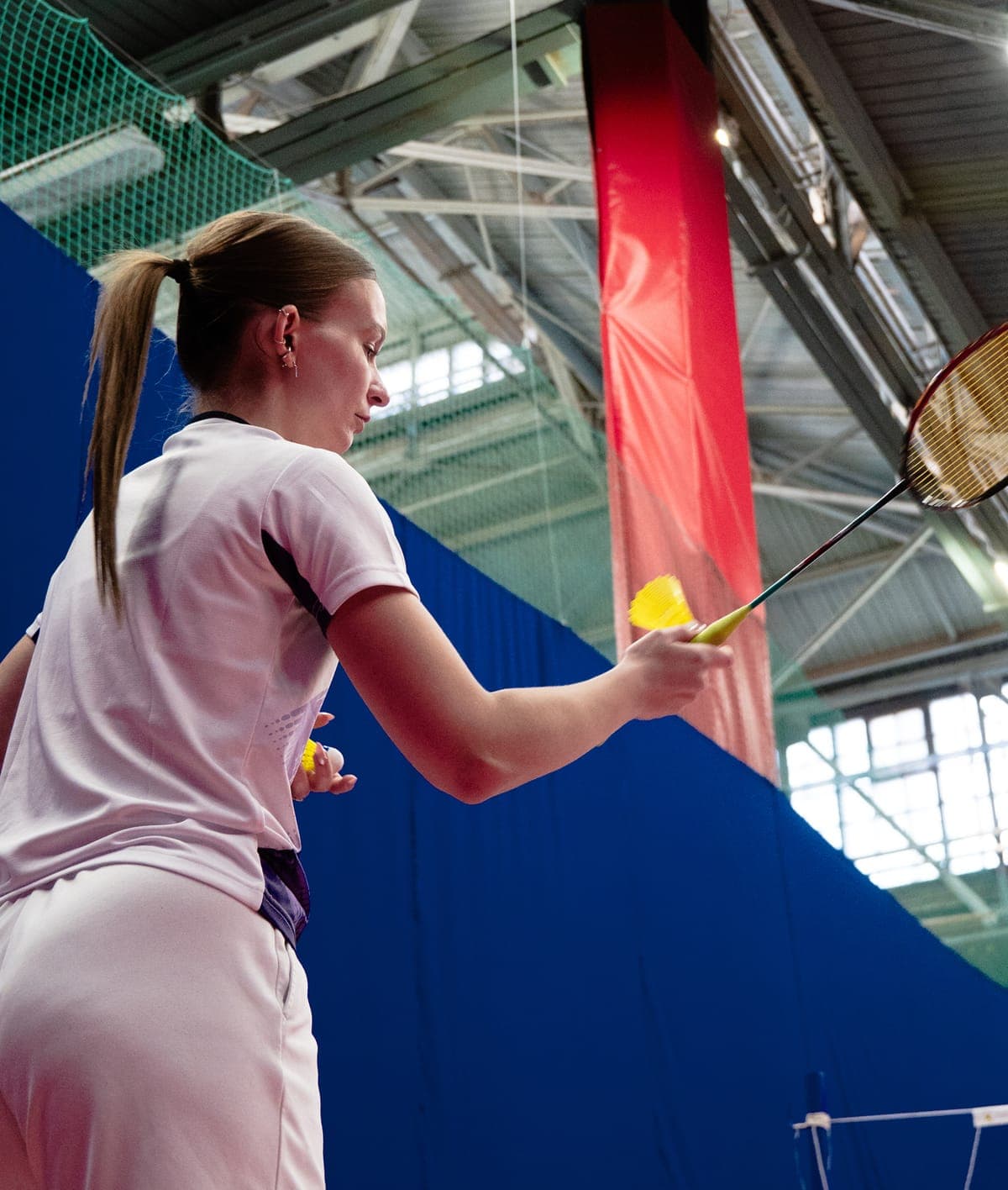 Женщина на персональной тренировке по бадминтону в зале Найт Бадминтон (Night Badminton), Санкт-Петербург